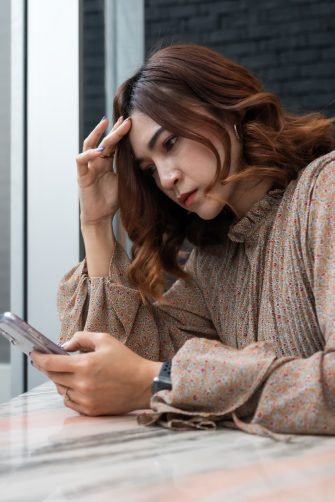 Concerned woman looking at her smartphone
