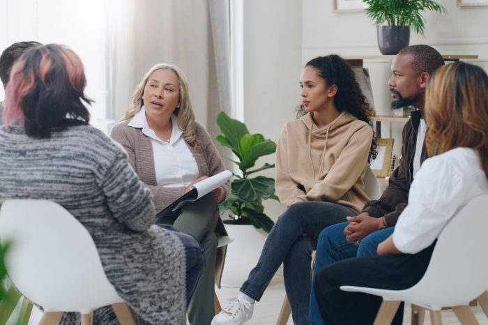 Counseling, group and psychology discussion with group of diversity people in therapy for depression, stress and anxiety. Men and women healing during psychologist meeting talking about mental health.