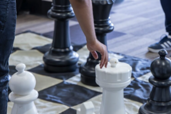 People playing with a giant chess board