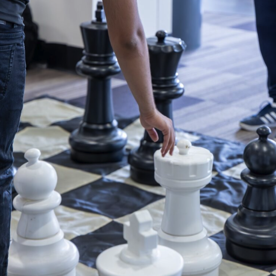 People playing with a giant chess board