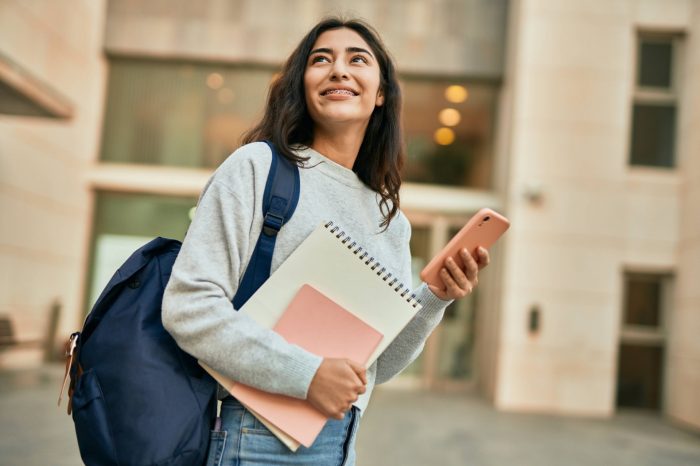 Young middle east student girl smiling happy using smartphone at the city.