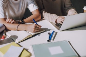 Male Asian student making new project with his friend at table