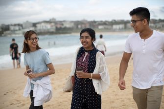 Students walking in sand at Bondi beach