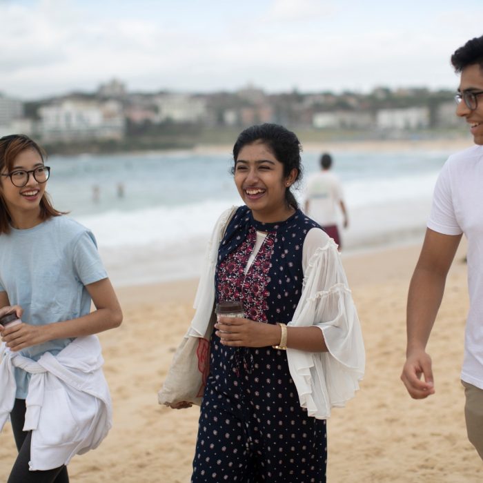 Students walking in sand at Bondi beach