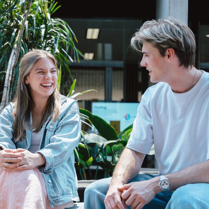 A male an female student sitting and talking in the L5 courtyard