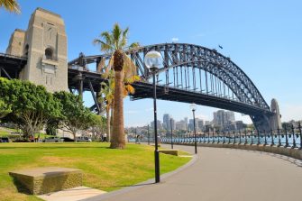 Side view of Sydney Harbour bridge in bright blue sky.