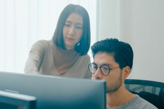 Group Adult Asia male, female freelance meeting write prompt AI bot IT app smart program nomad, video game, talk strategy, discuss plan, user interface, designer, big data center on desktop computer.